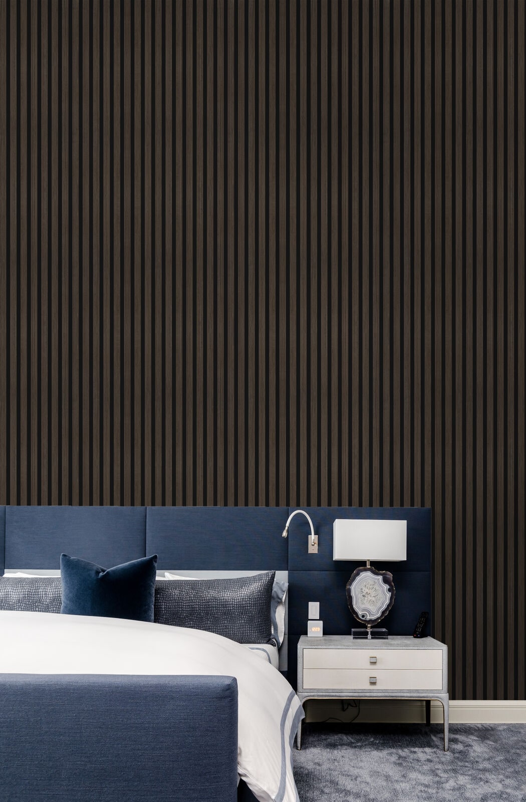 Dark walnut acoustic slat wall panels in a bedroom